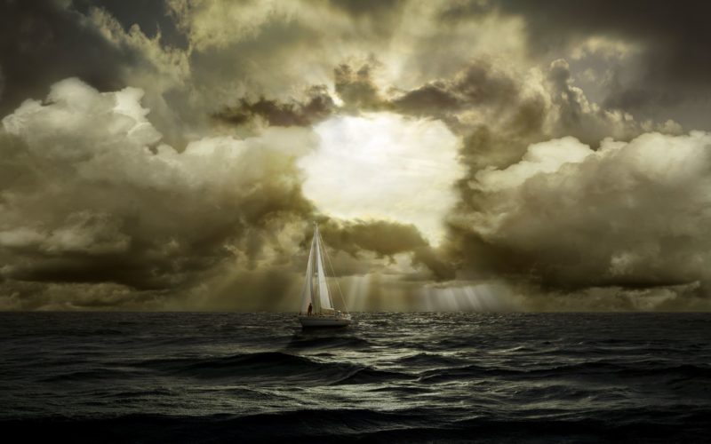 Segelboot in Sturm mit dunklen Wolken